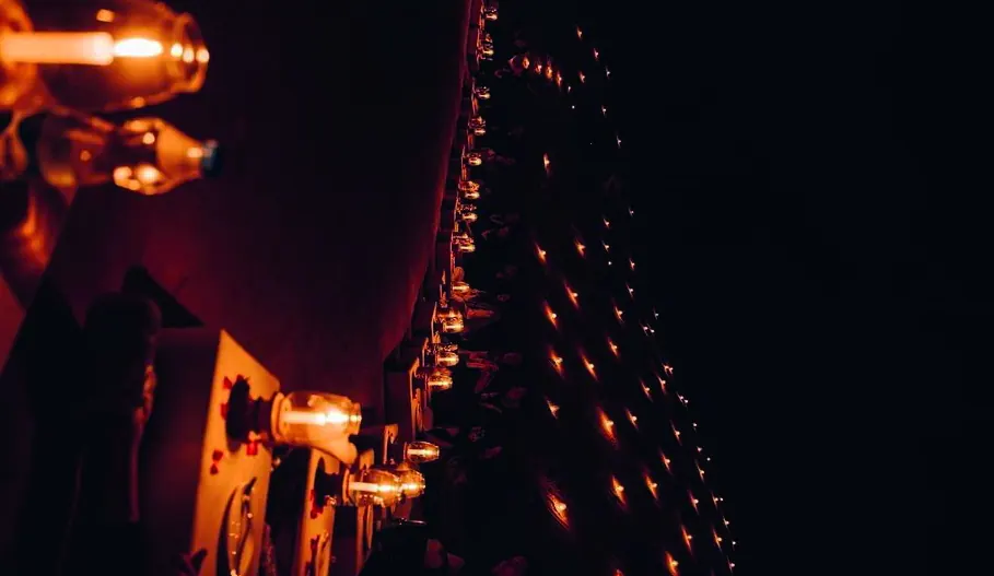 A row of flickering lights along a dark wall.