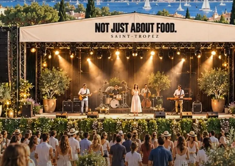 A band playing on the festival stage at dusk, the crowd gathered in front.